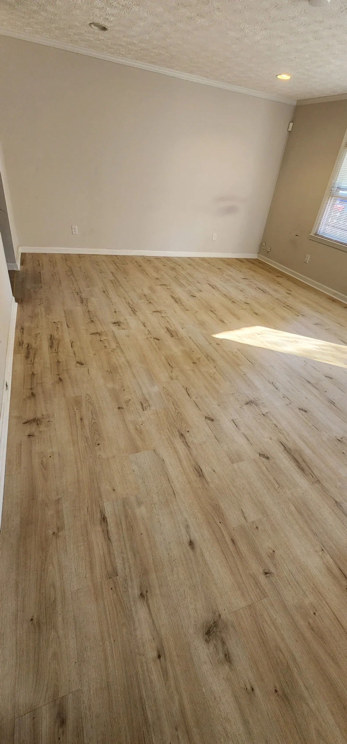 Light oak luxury vinyl plank flooring in an empty living room
