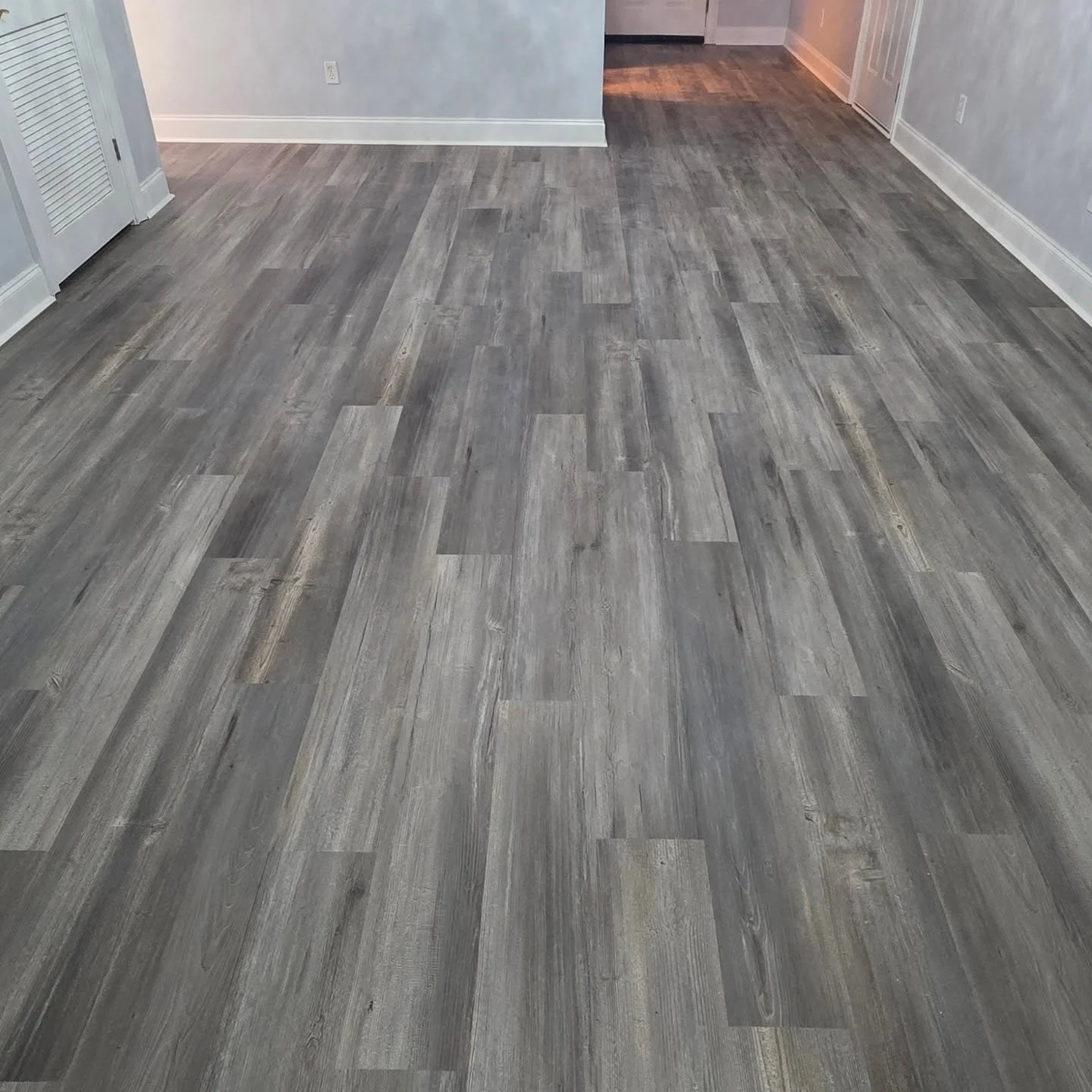 Gray-toned luxury vinyl plank flooring in a bedroom